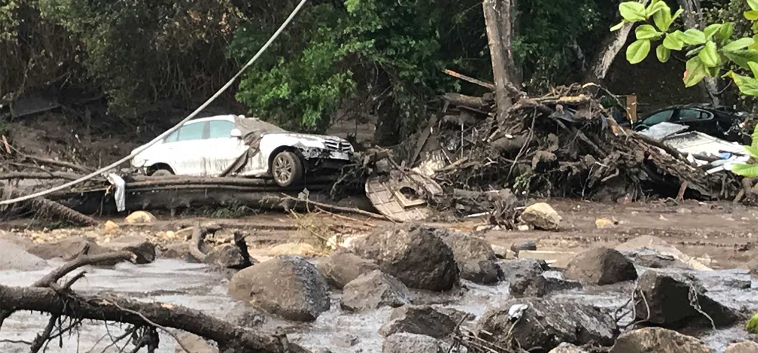 car washed into mudslide, debris and boulders